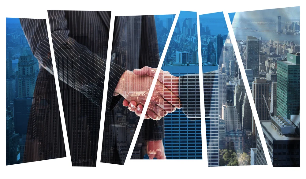 Business people shaking hands against city skyline